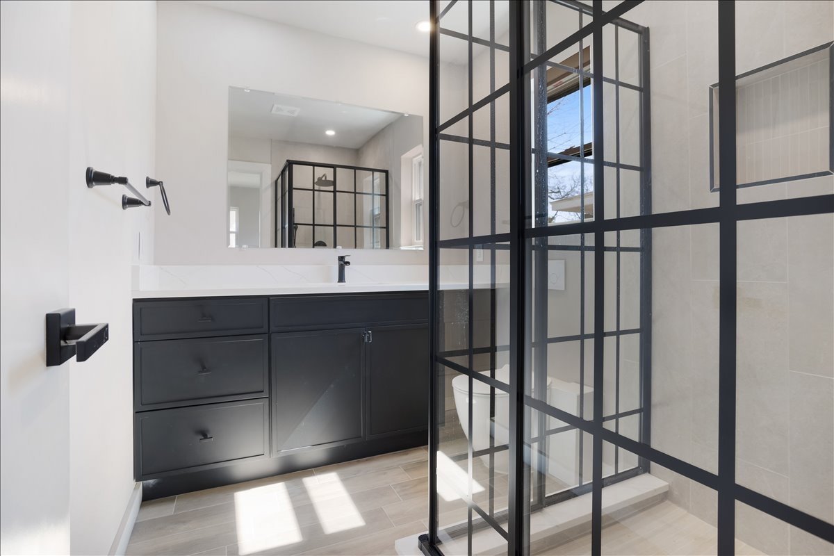 Renovated bathroom with black grid glass shower