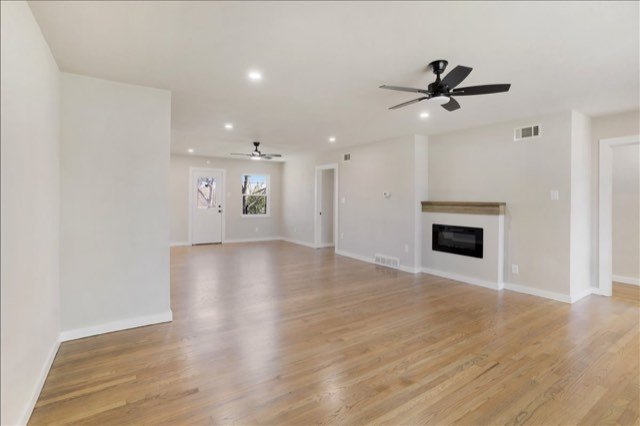 Open living room with new wood floors and fireplace
